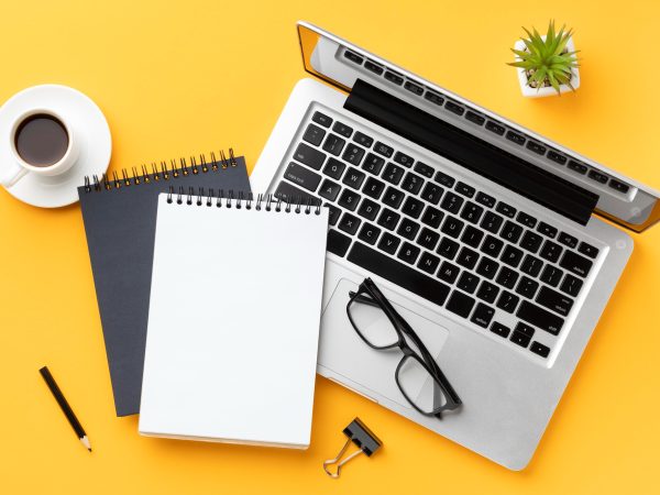 top-view-office-desk-composition-with-notepad